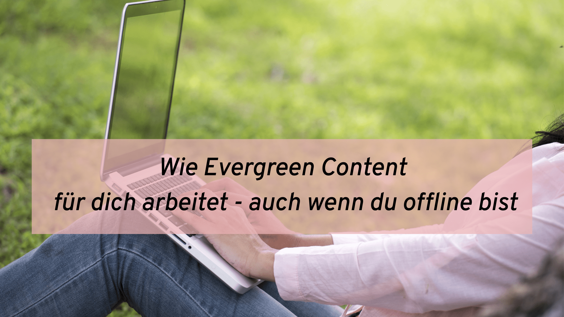Frau mit Laptop sitzt im Rasen